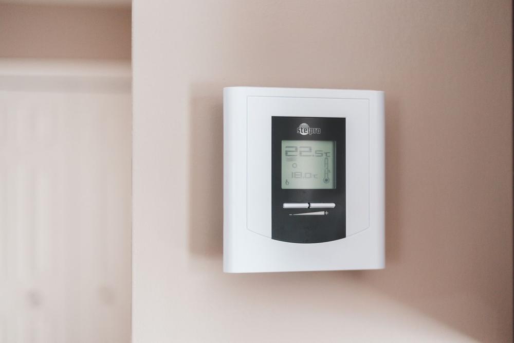 A thermostat mounted on a home wall